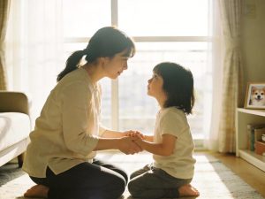 台灣居家客廳窗邊自然光下，大人蹲下來與小孩平視的溫馨陪伴畫面